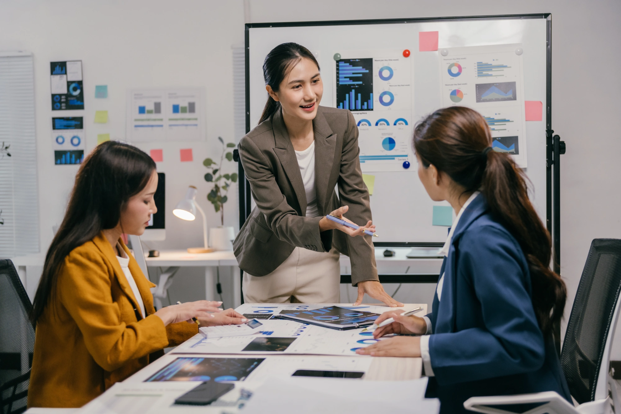 Three women discussing business in office.