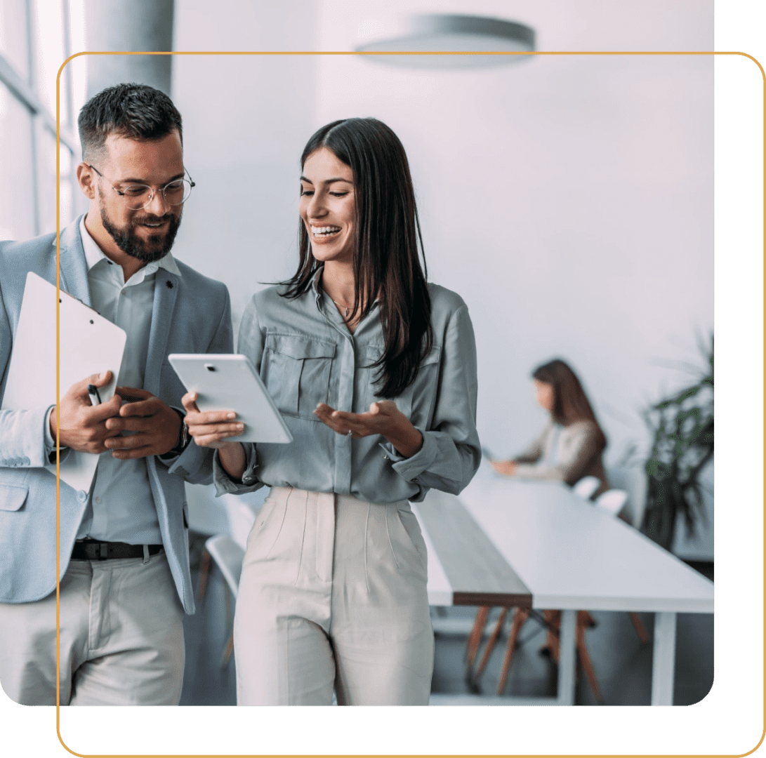 Two colleagues sharing ideas on digital devices in a modern office.