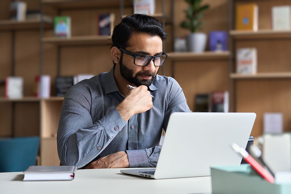 Man working on laptop in modern office.