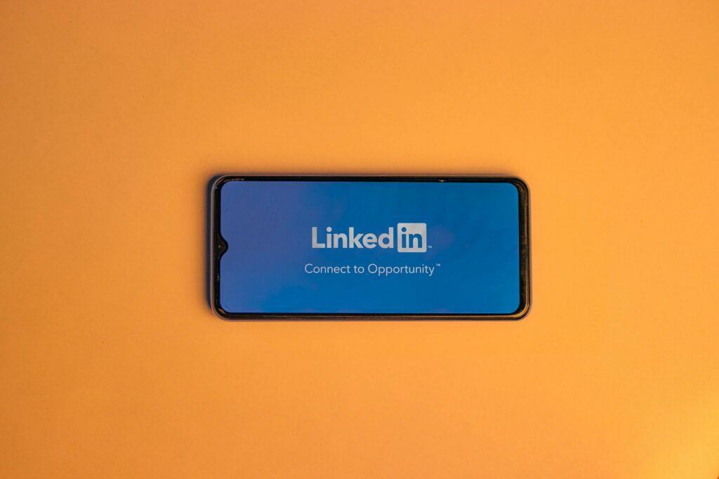Smartphone with LinkedIn logo on orange background