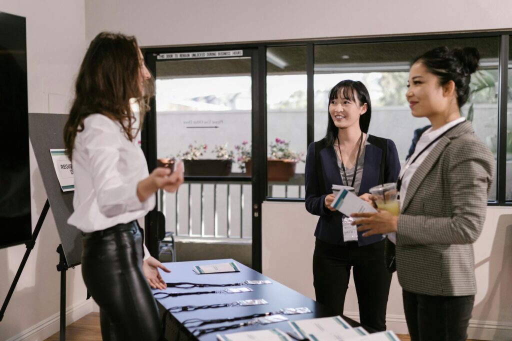 Women networking at conference registration table