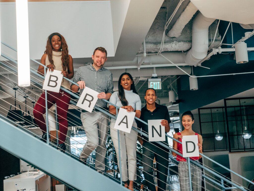Team on stairs holding brand letter signs