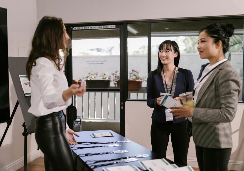 Women networking at conference registration table