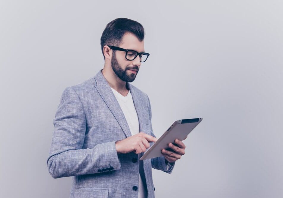 Bearded man with glasses using tablet